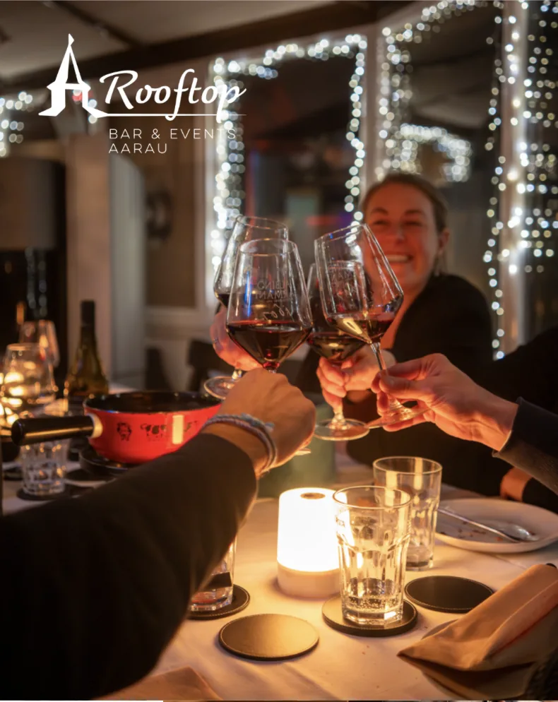 Anstossen beim Fondue unter dicht gehängten Lichterketten im Rooftop Aarau