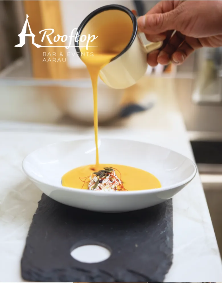 Kürbissuppe wird als Winterzauber-Vorspeise am Tisch angerichtet