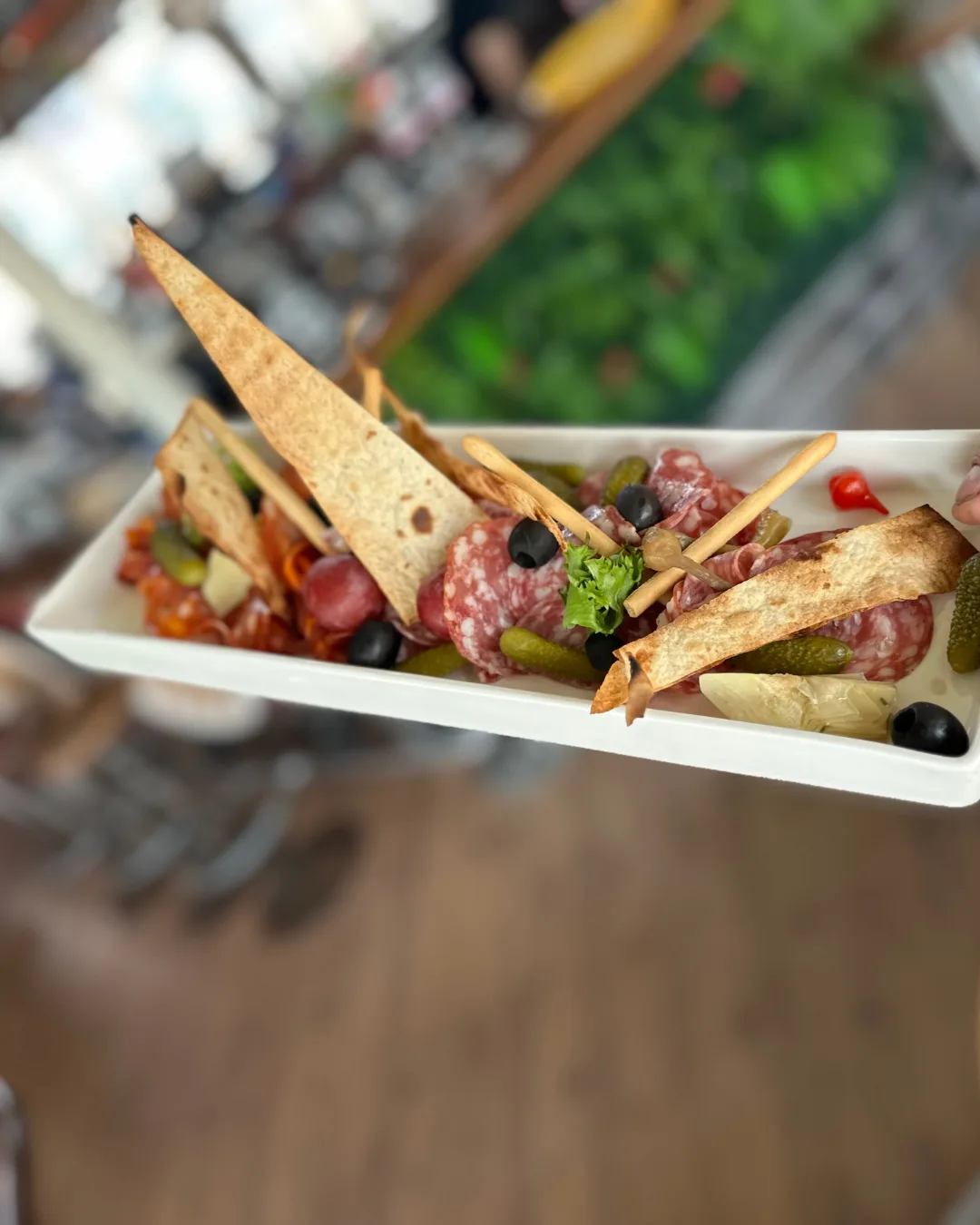Antipasti-Platte mit Salami, Oliven und knusprigem Gebäck