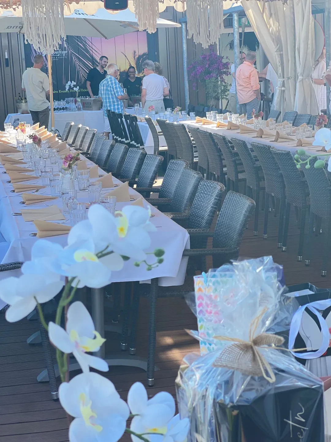 Lange gedeckte Tafeln mit Gästen bei einem Event im Rooftop Aarau