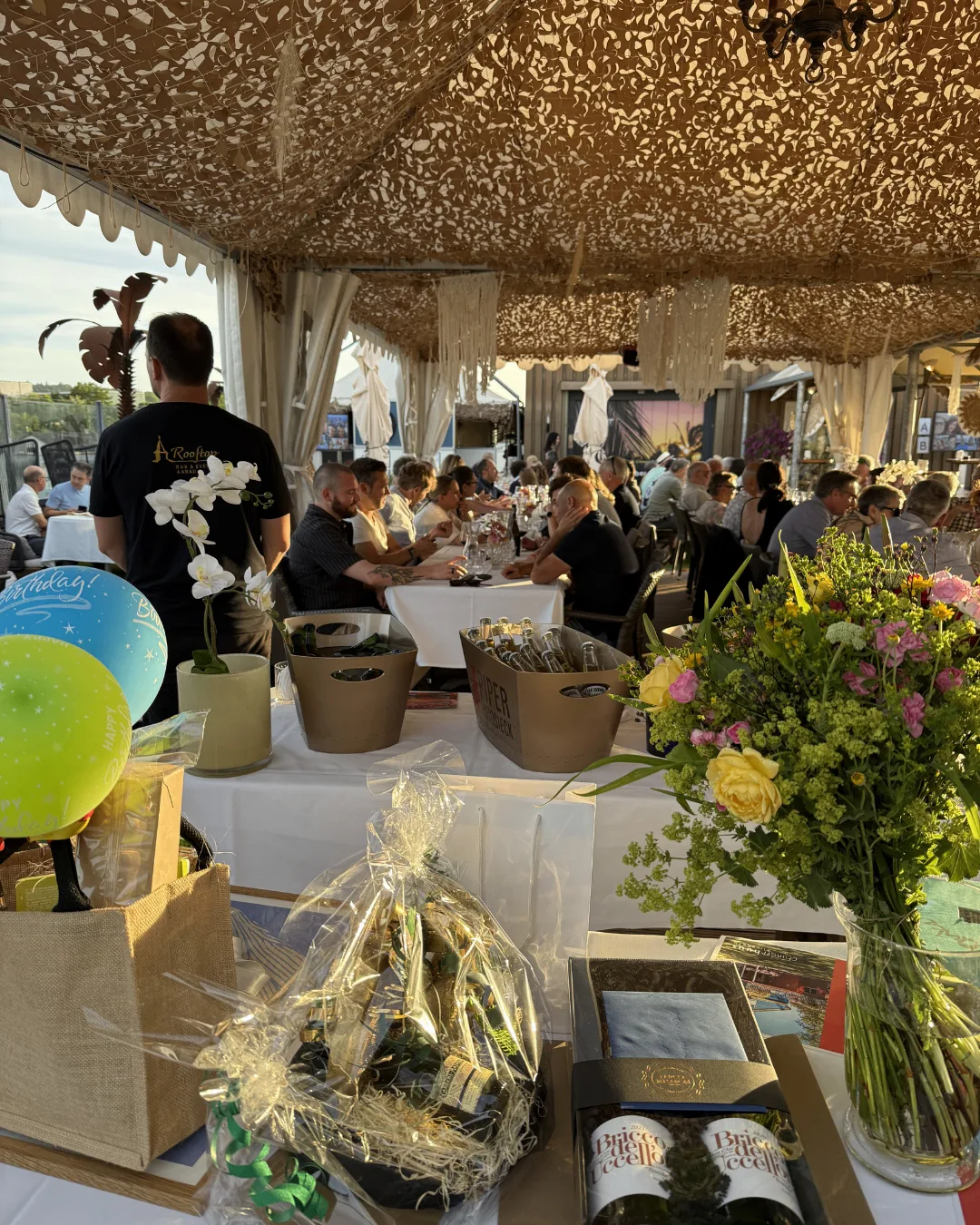 Eventstimmung mit gedeckten Tischen und Gästen in der Rooftop Eventlocation