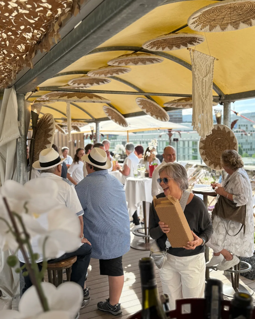 White Party Stimmung mit Gästen unter den Sonnenschirmen