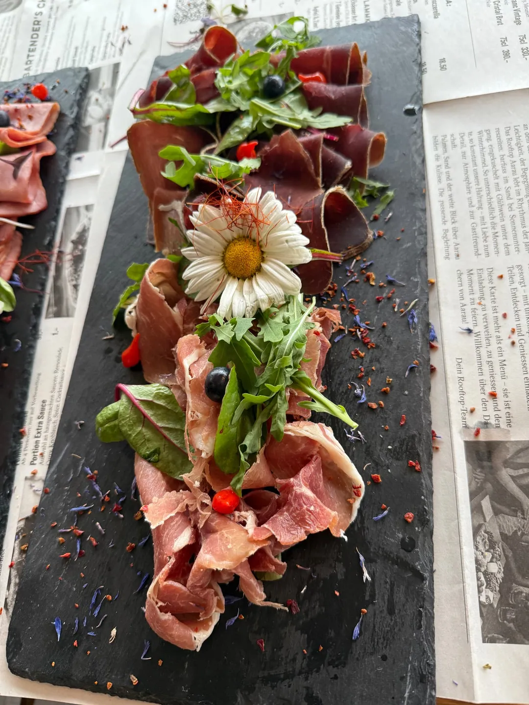 Trockenfleisch- und Rohschinkenplatte mit Blüten-Deko im Rooftop Aarau