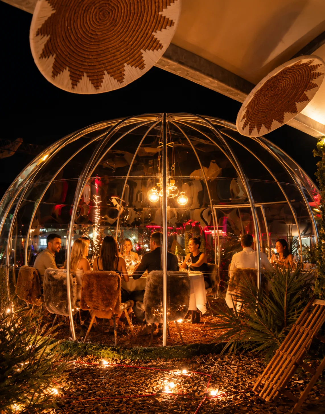 Beleuchtetes Fondue-Iglu bei Nacht für ein Weihnachtsessen über den Dächern von Aarau